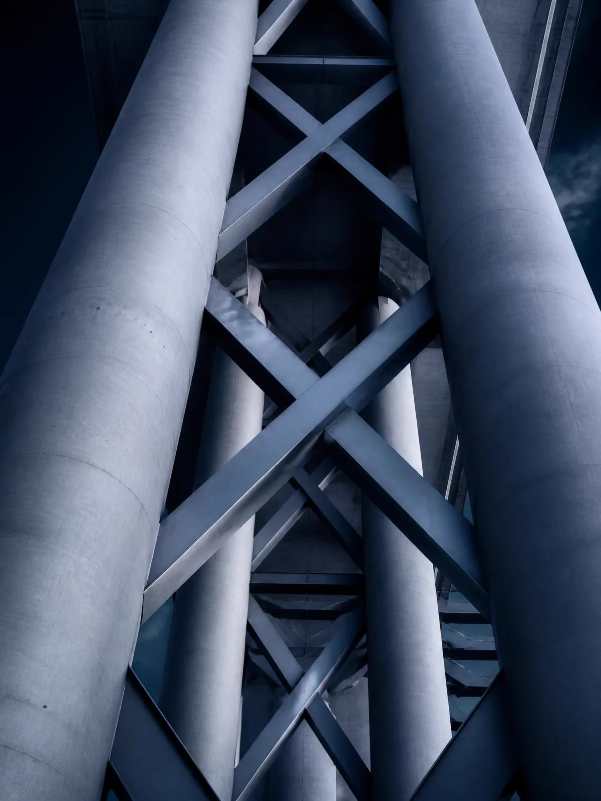 Monumental concrete columns and steel cross-bracing viewed from below
